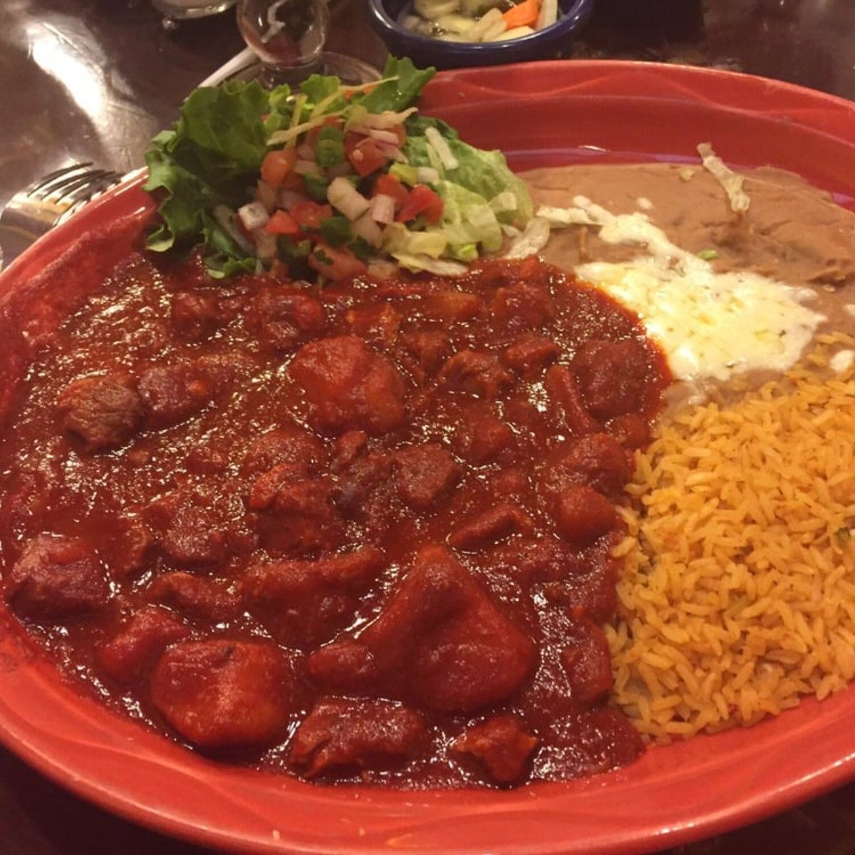 A plate of food with rice and salsa on a table