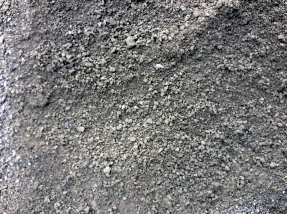 A pile of gravel is sitting on top of a pile of dirt.