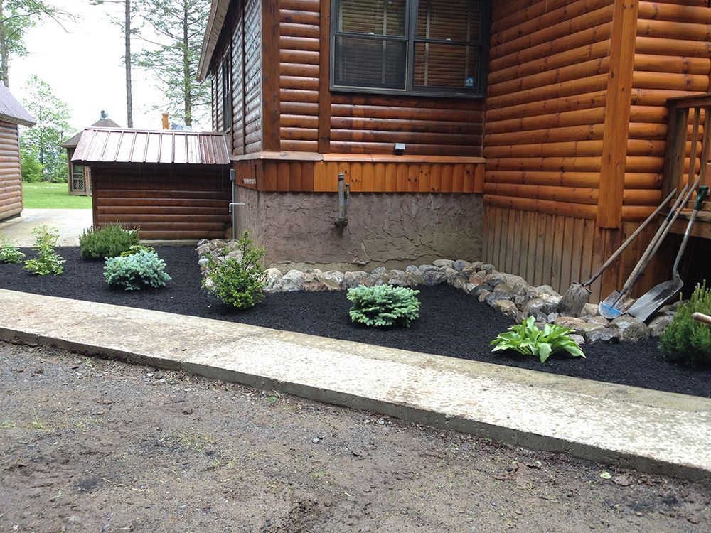 A wooden house with a garden in front of it