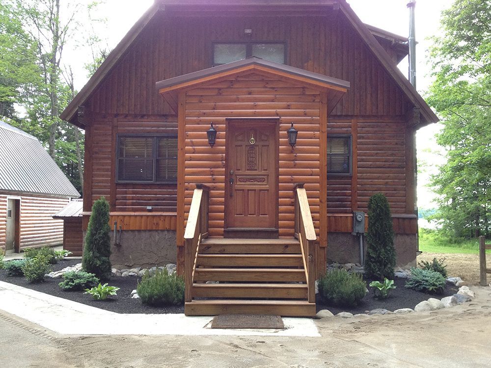 A log cabin with stairs leading up to the front door