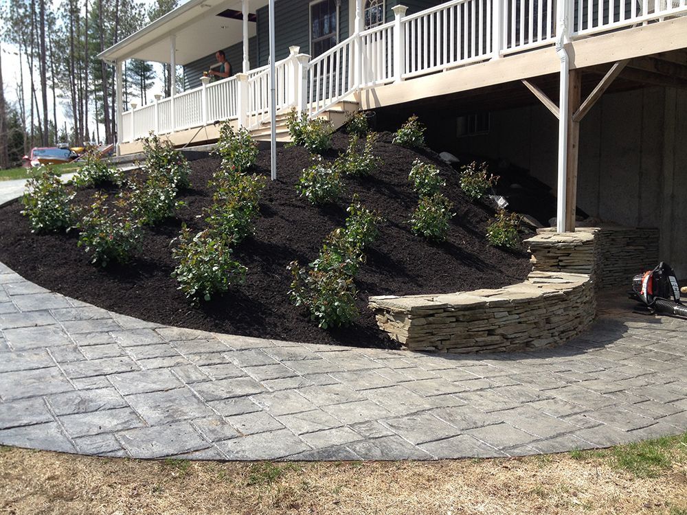 A concrete walkway leading to a house with a white railing
