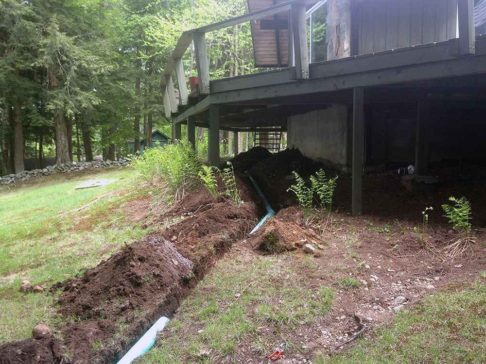 A drain pipe is being installed in front of a house.