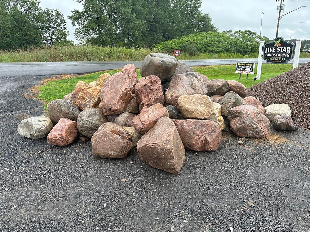 A pile of rocks is sitting on the side of a road.
