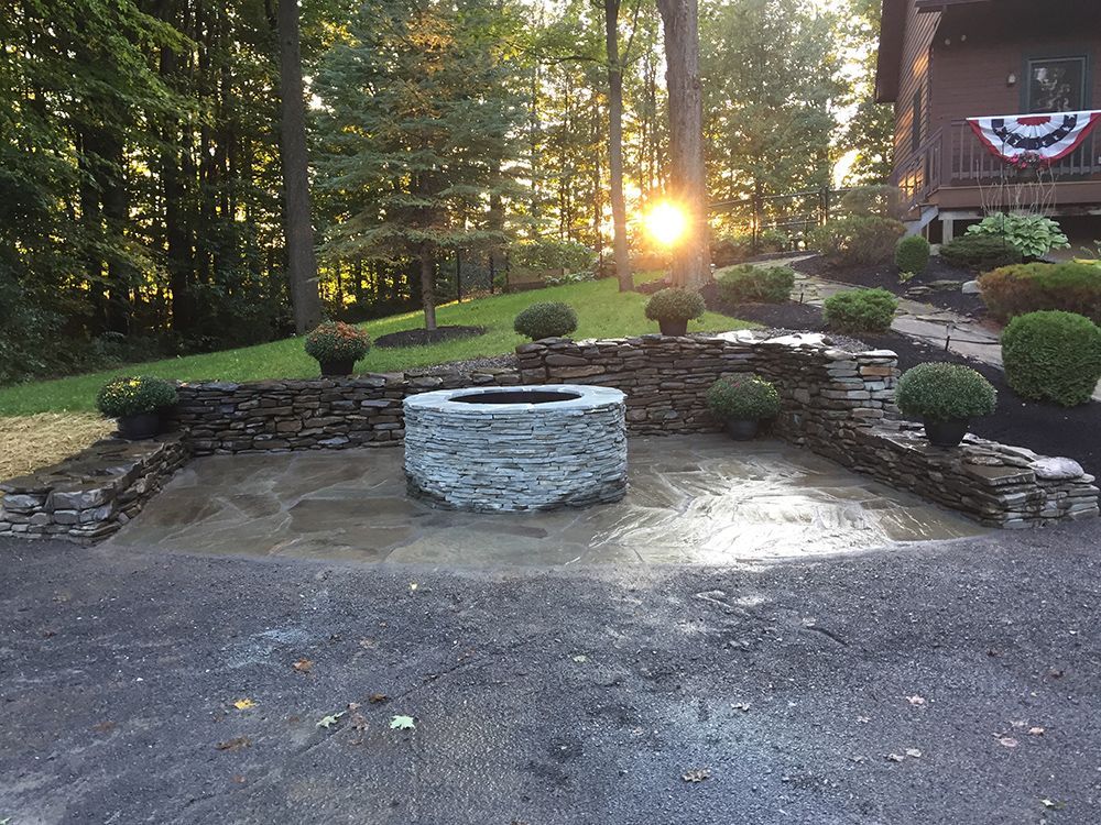 A fire pit is sitting in the middle of a driveway in front of a house.