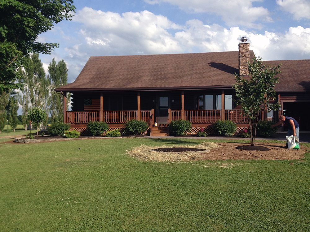 A man is standing in front of a large house