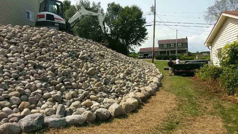 A large pile of rocks is sitting in front of a house.