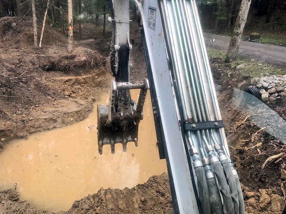 A bulldozer is digging a hole in the mud.