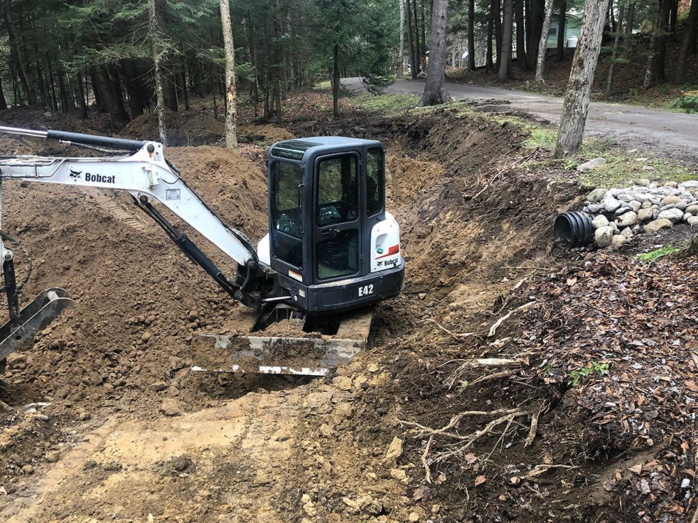 A small excavator is digging a hole in the dirt.
