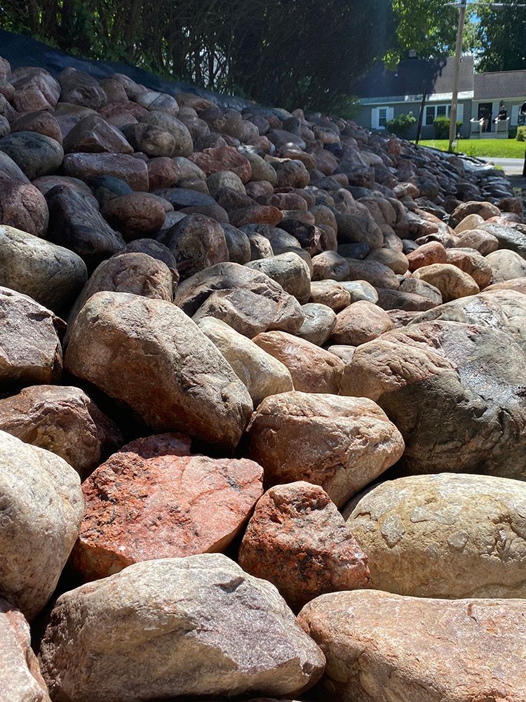 A pile of rocks is sitting in front of a house.