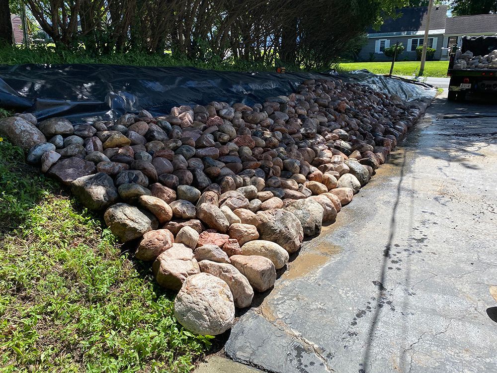 A pile of rocks is sitting on the side of a road.