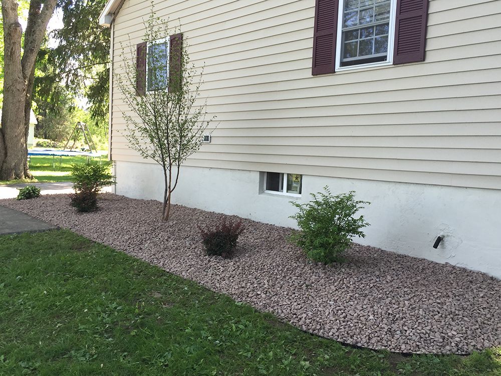 A house with a lot of gravel in front of it.