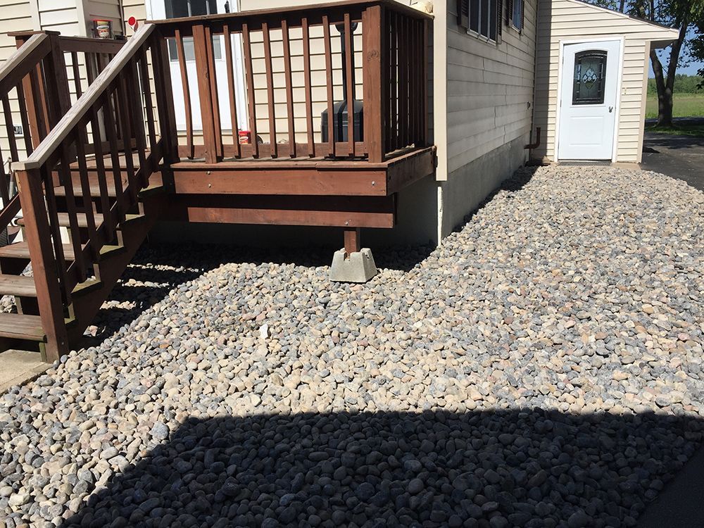 A house with a deck and stairs in front of it