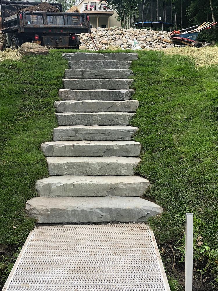 A set of stairs leading up to a grassy hill.