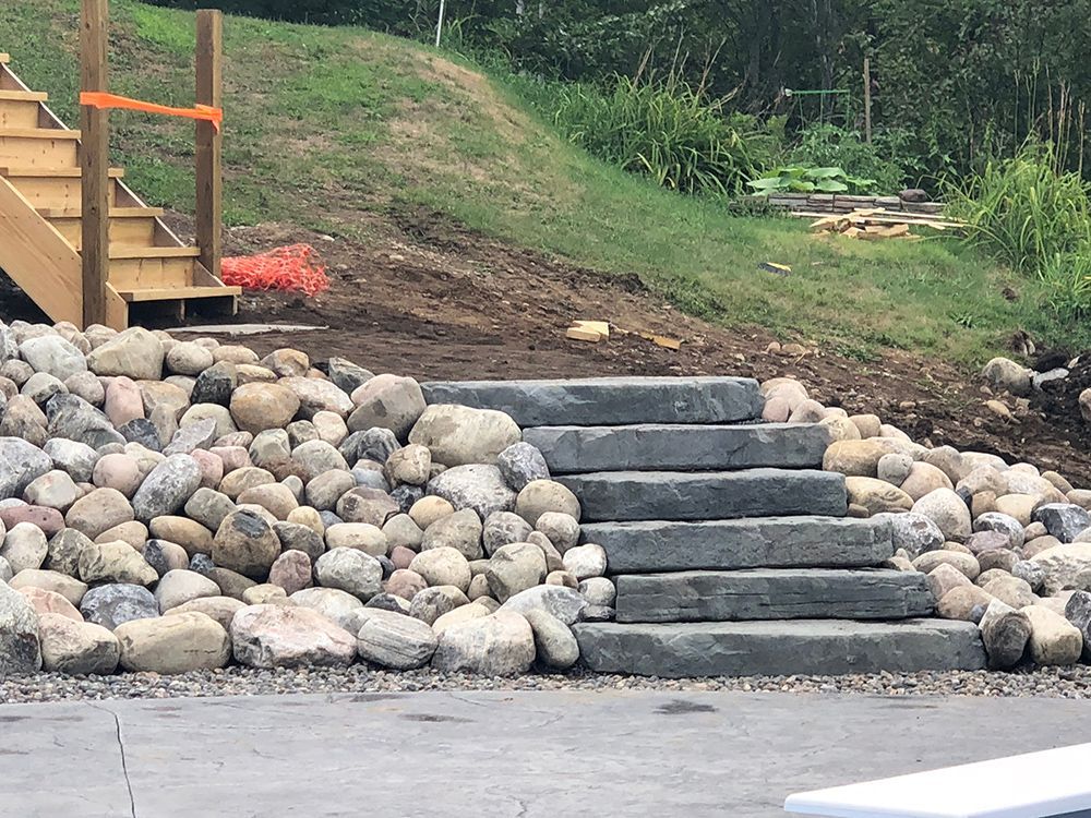 A set of stairs surrounded by rocks in a yard.