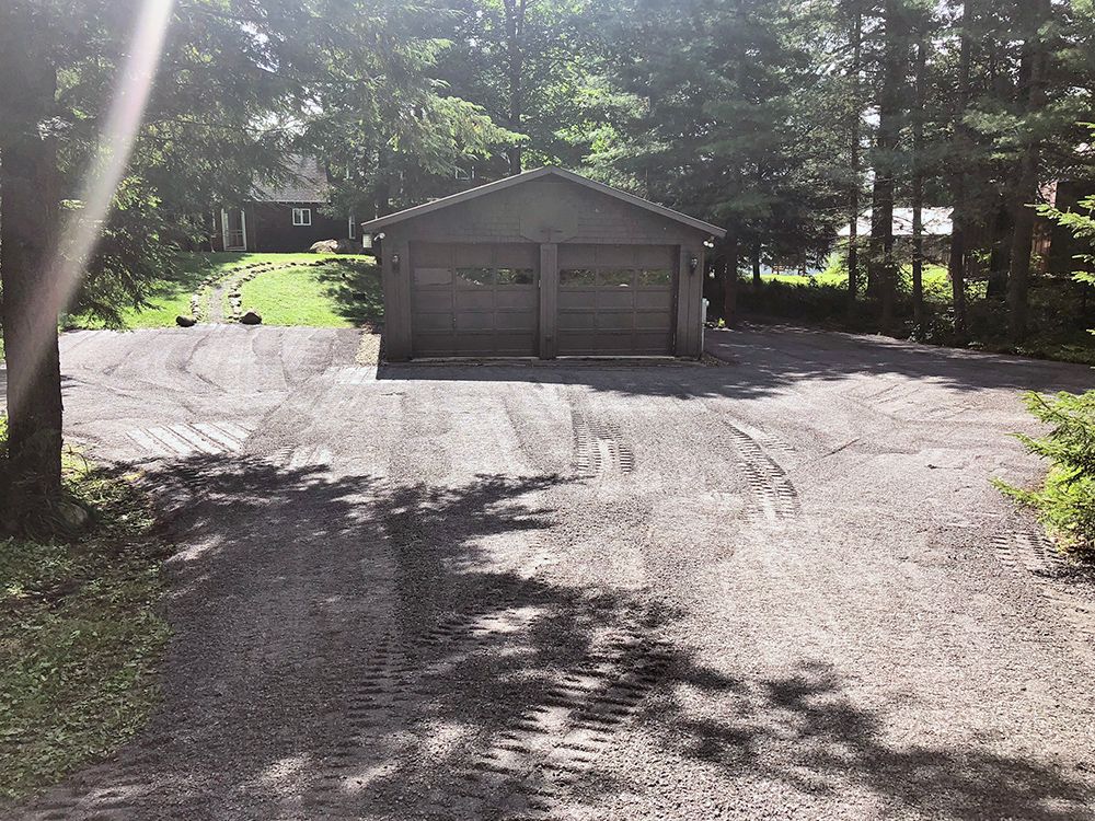 A driveway leading to a garage with two garage doors