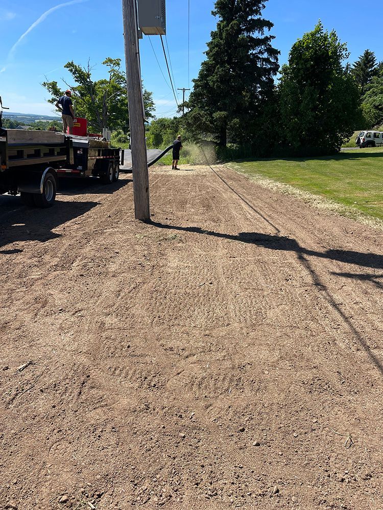 A truck is driving down a dirt road next to a power pole.