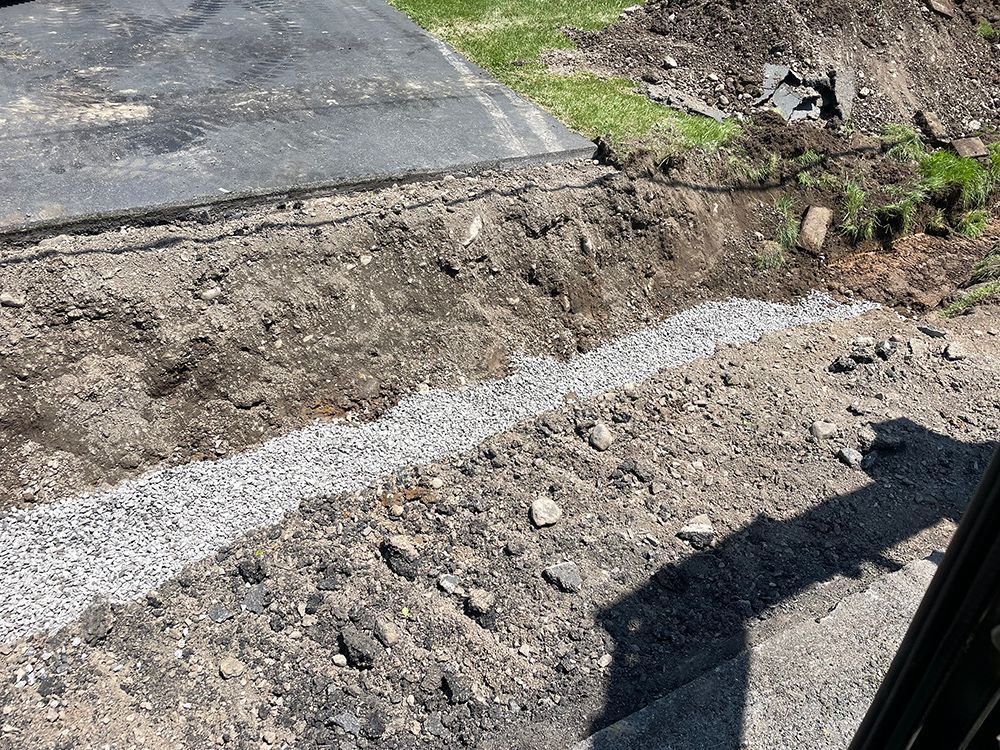 A pile of dirt and gravel is sitting next to a road.