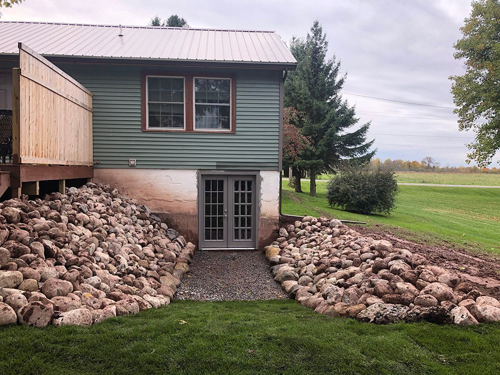 A house with a large pile of rocks in front of it.