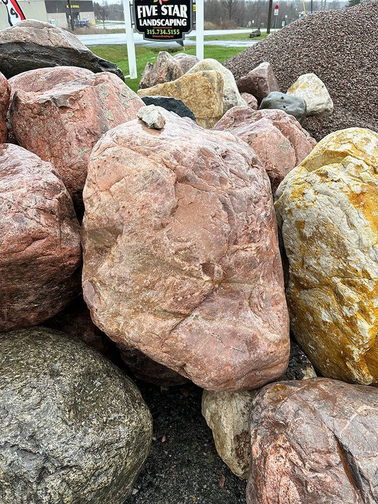 A pile of rocks with a sign in the background.
