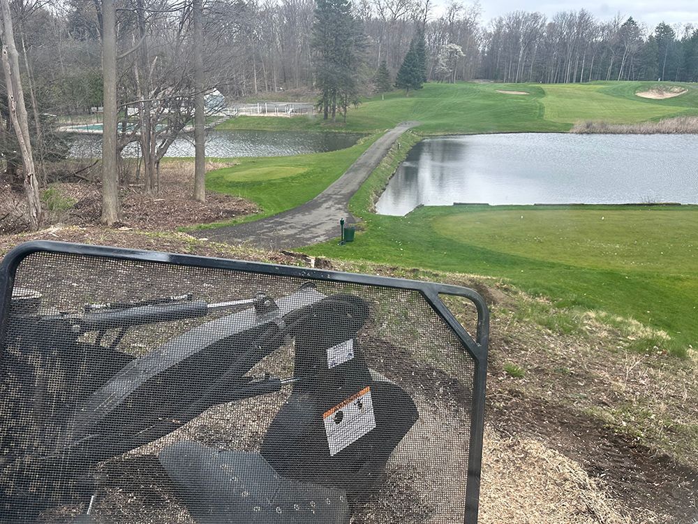 A view of a golf course from behind a fence