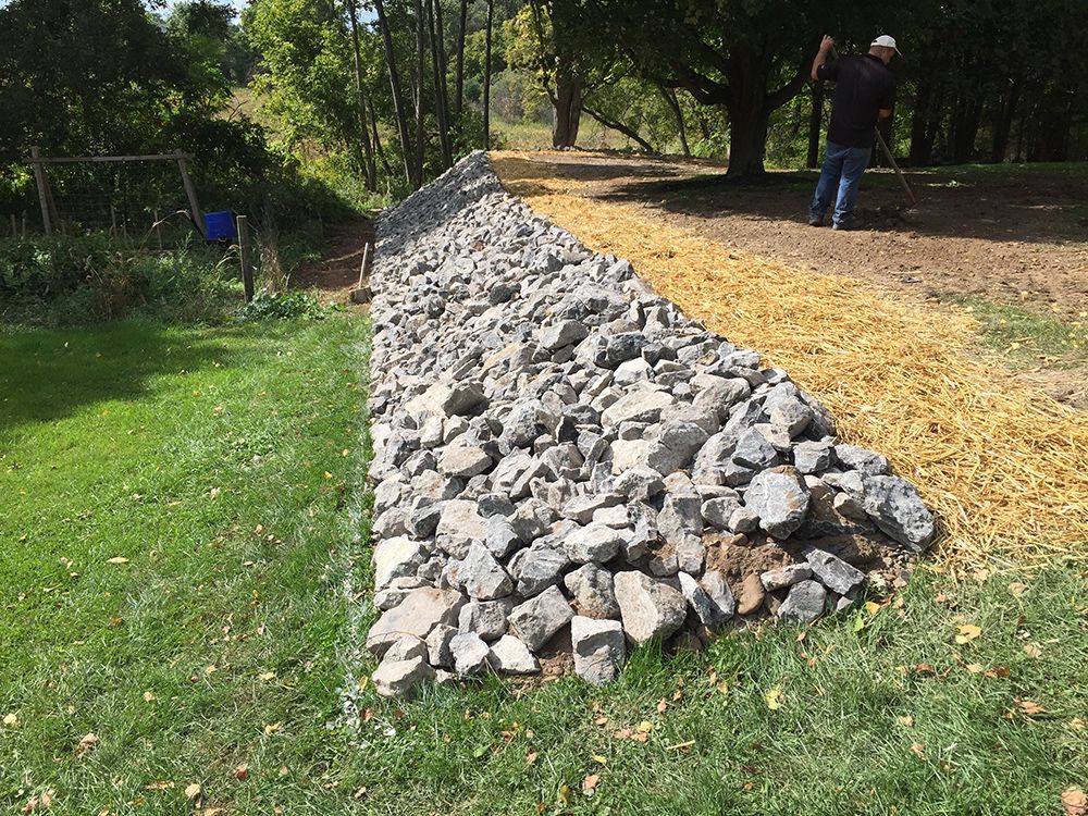 A pile of rocks is sitting on top of a lush green field.