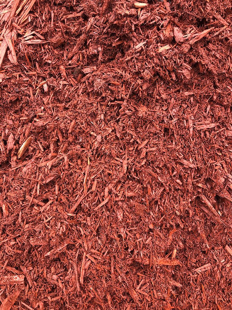 A pile of red mulch is sitting on the ground.