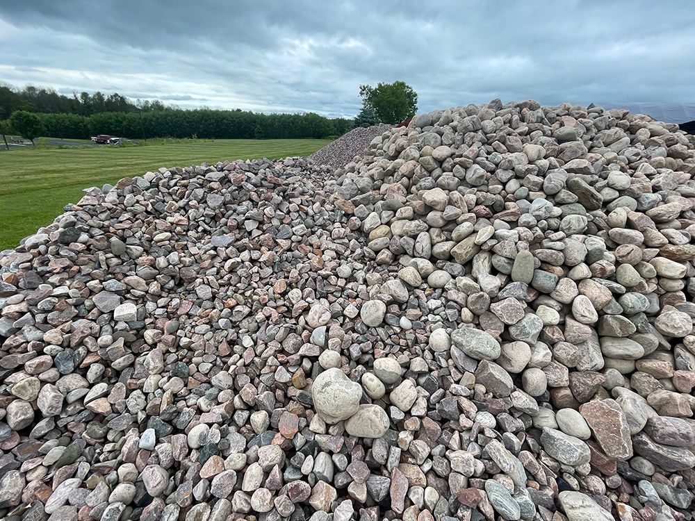 A pile of rocks is sitting on top of a grassy field.