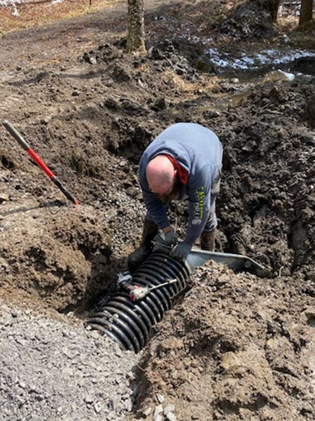 A man is digging in the dirt with a shovel.