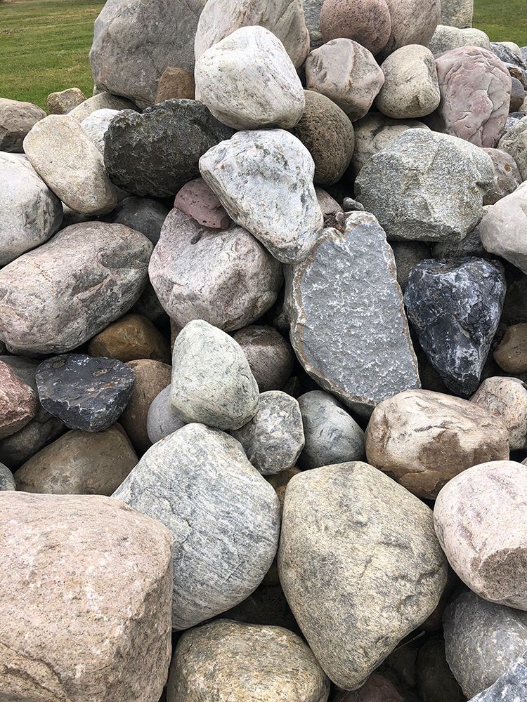 A pile of rocks sitting on top of each other in a field.