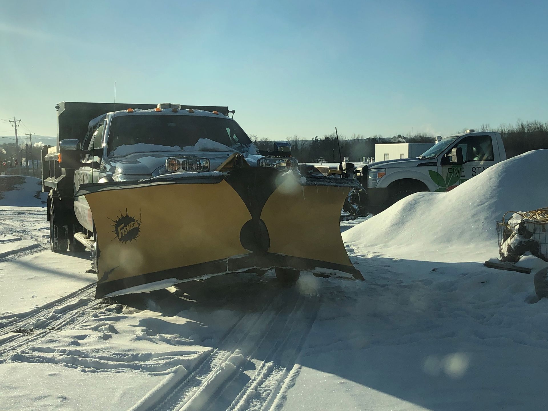 A snow plow is plowing snow on a snowy road.