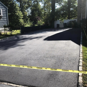 A driveway with yellow tape that says caution