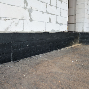 A corner of a building with black paint on it