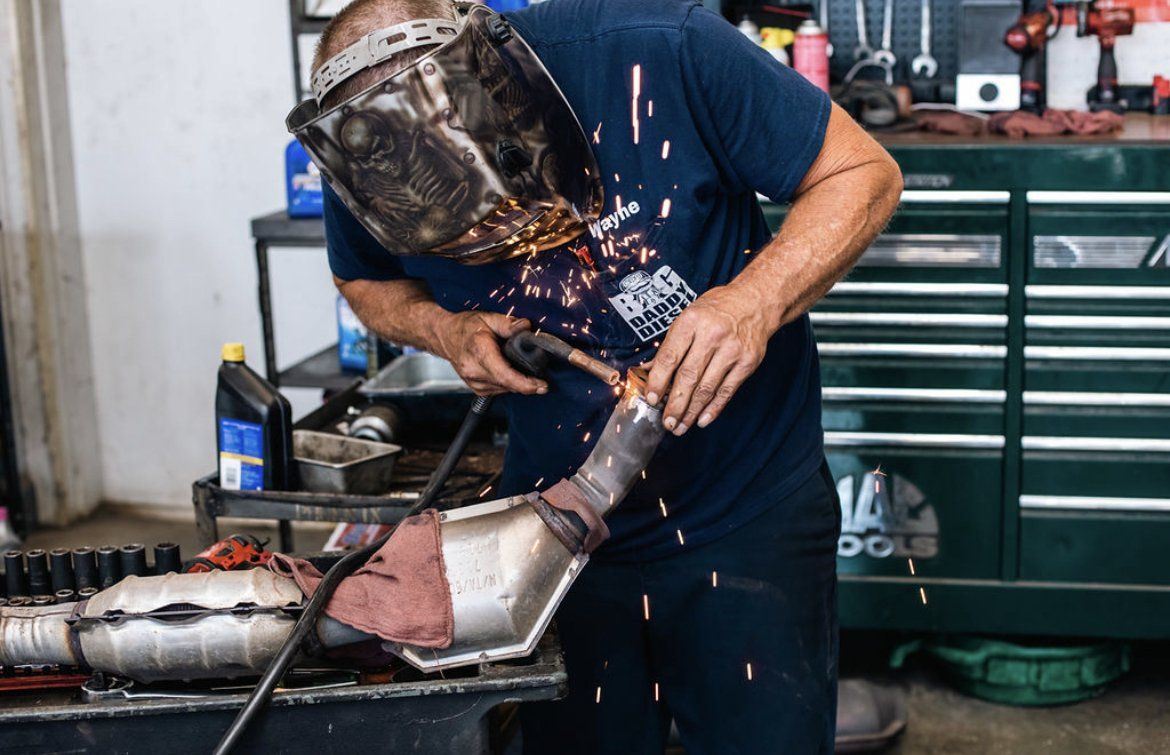 Big Daddy Diesel mechanic working with welding helmet
