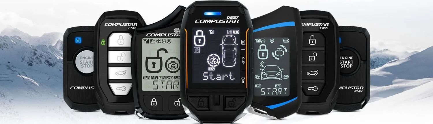 A group of compustar remote are sitting next to each other on a table.