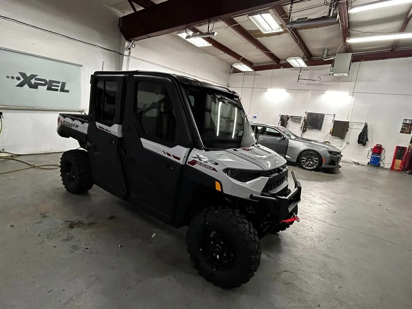A white and black ATV is parked in a garage.