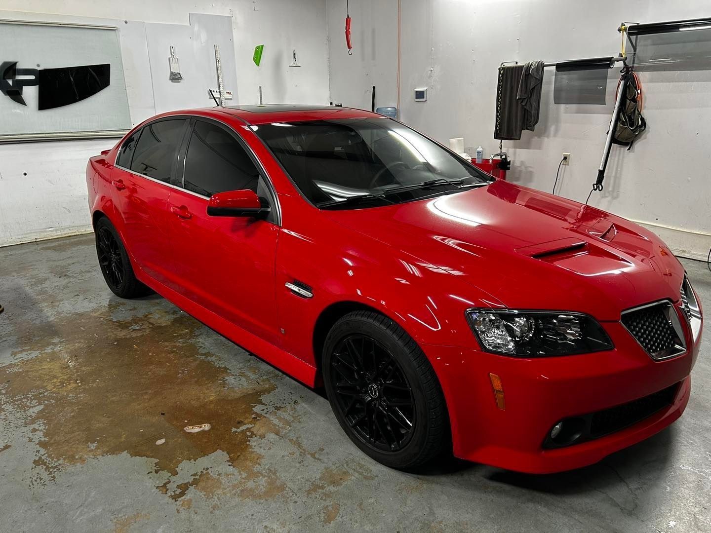 A red car is parked in a garage.