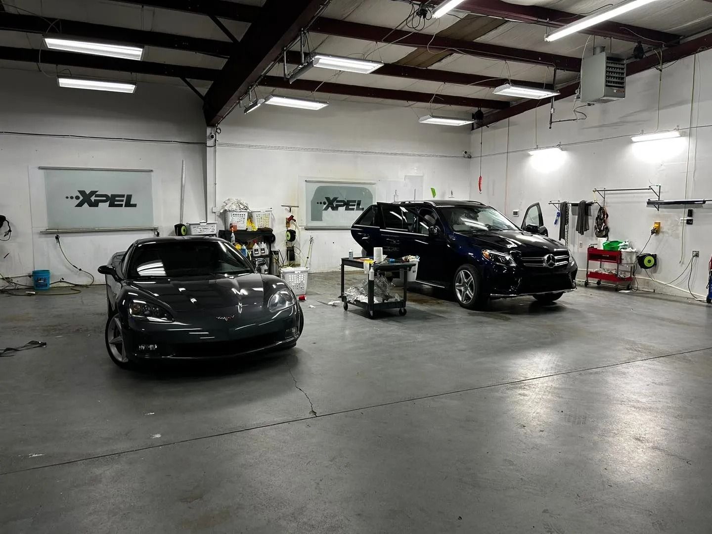 A couple of cars are parked in a garage.