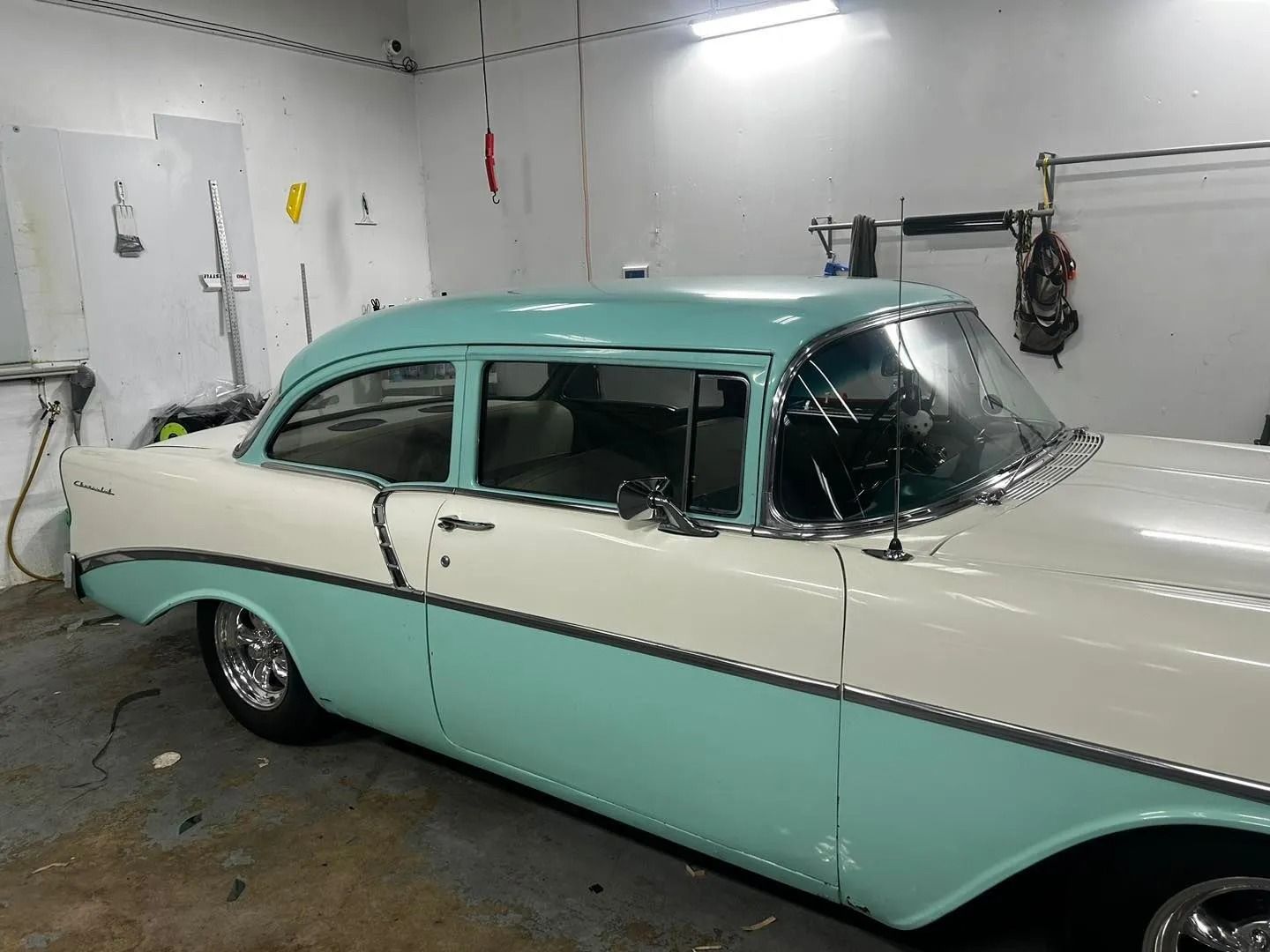 A white and blue car is parked in a garage.