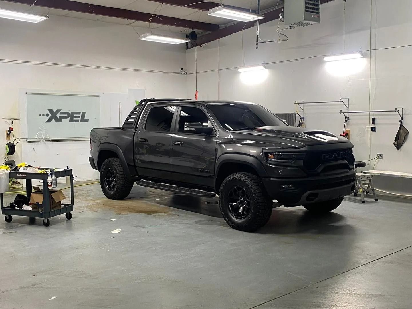 A black truck is parked in a garage.