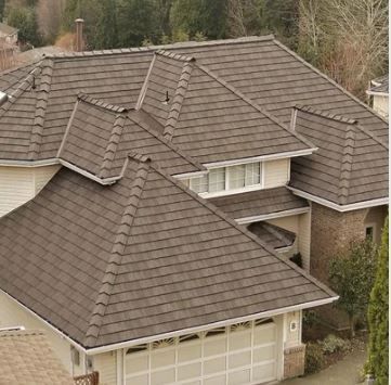 An aerial view of a house with a brown roof and a white garage door.
