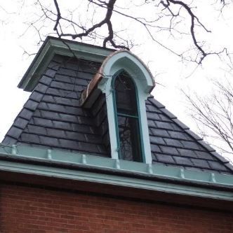 A brick building with a slate roof and a window