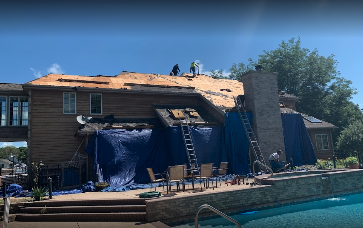 A house is being remodeled with a pool in the background.