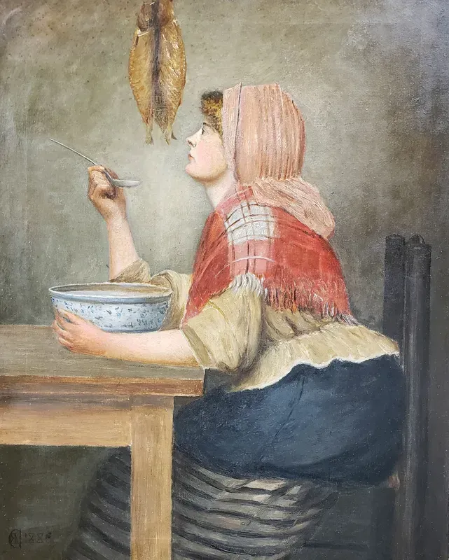 A person in a red shawl sits at a table, holding a spoon and bowl, looking up at a fish hanging from the ceiling.