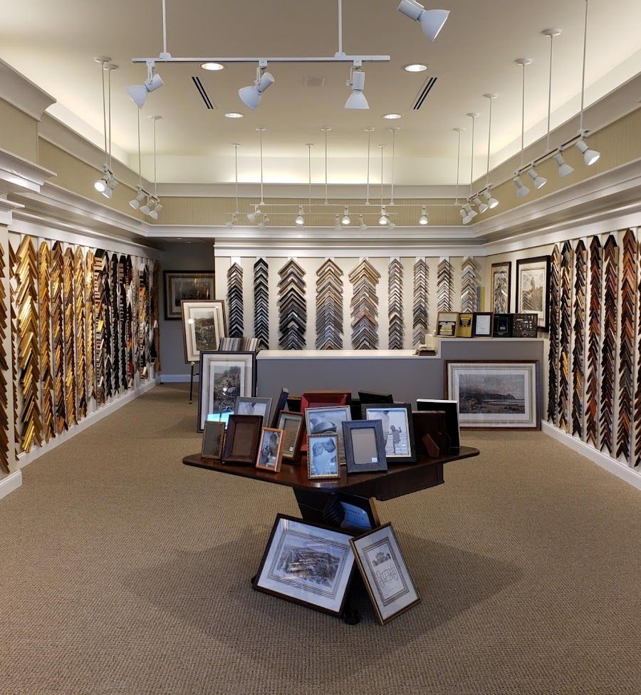 Art gallery display of framed textile and artwork panels in a bright white room