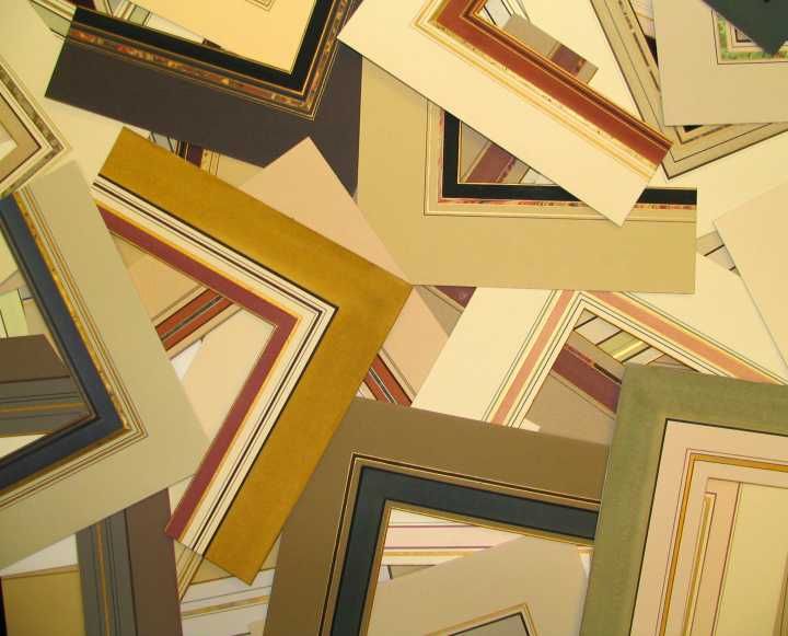 Scattered decorative picture frames in beige, gold, black, and cream tones