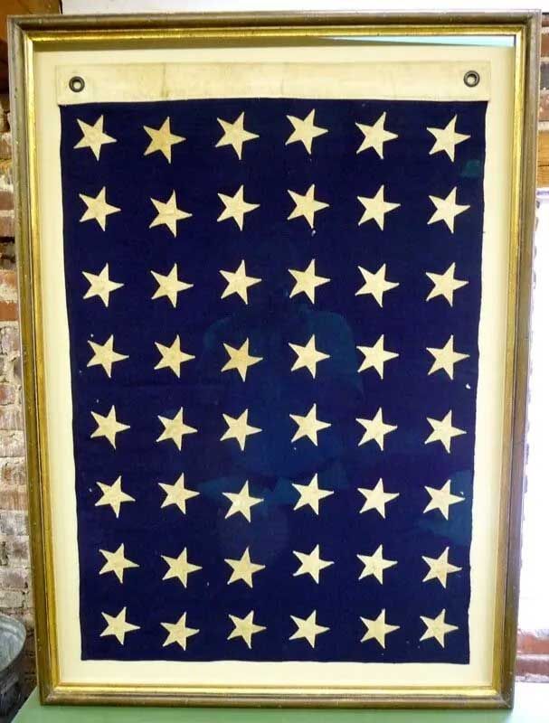 A framed navy blue rectangular field featuring a grid of 48 white stars, displayed against a light-colored background.