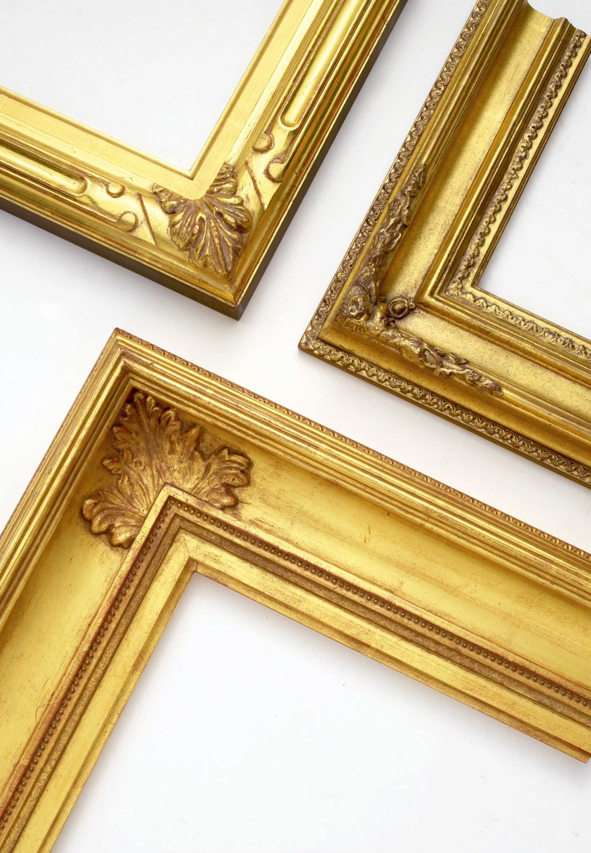 Three ornate, gold-colored picture frames arranged against a plain white background.