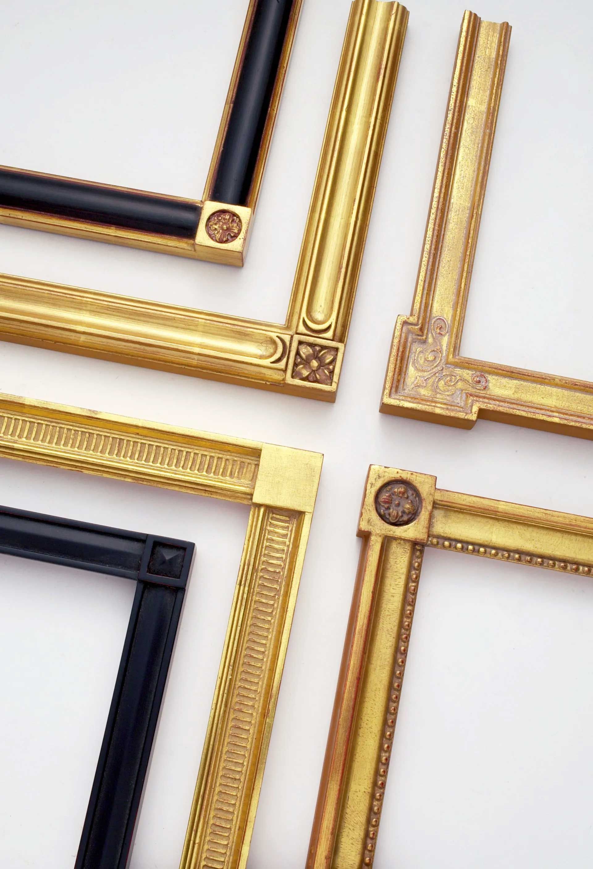 Four decorative rectangular picture frame corners in various gold and black ornate designs arranged against a white background.