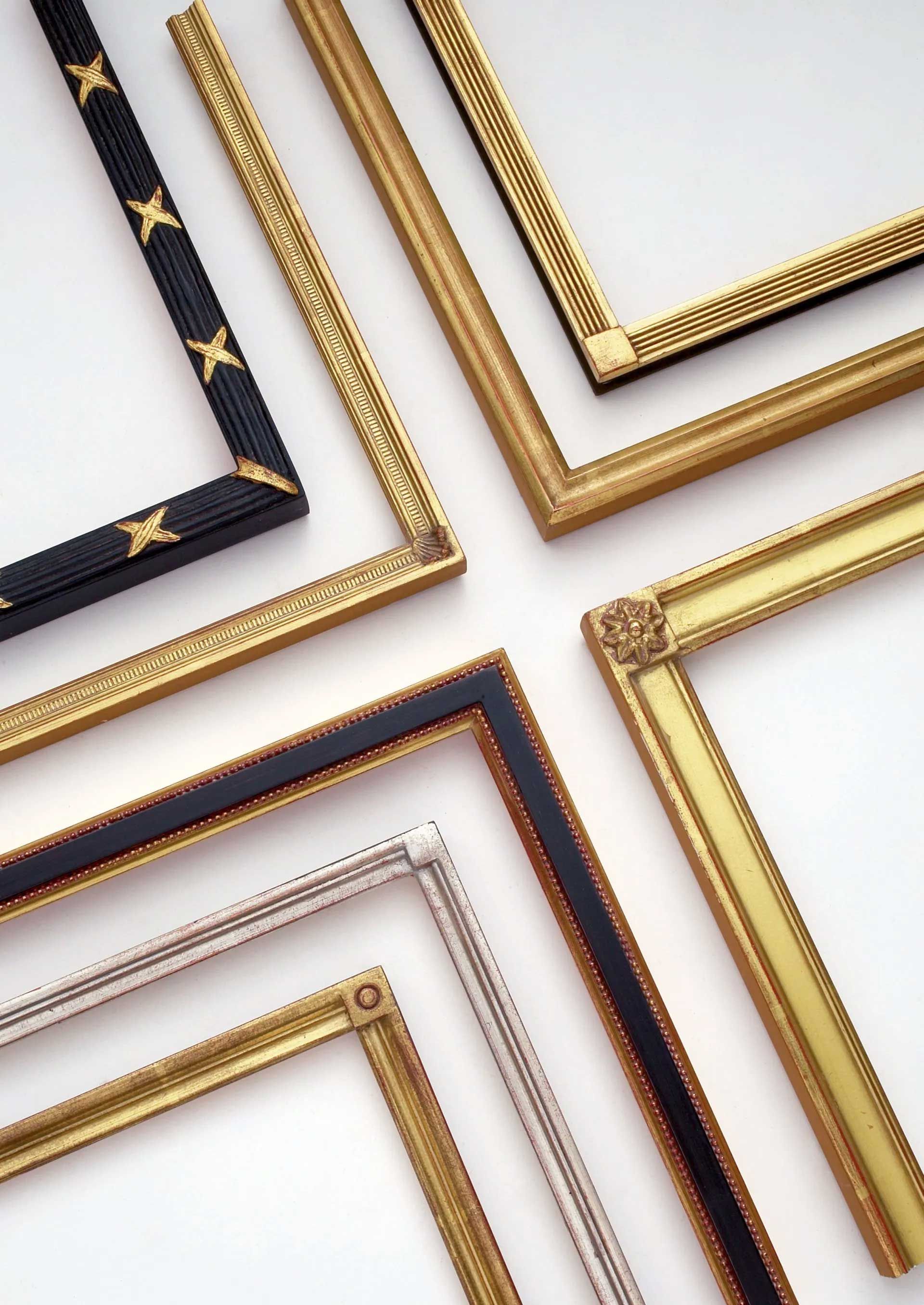 Six decorative, ornate picture frame corners in various gold, black, and silver metallic finishes arranged on white.