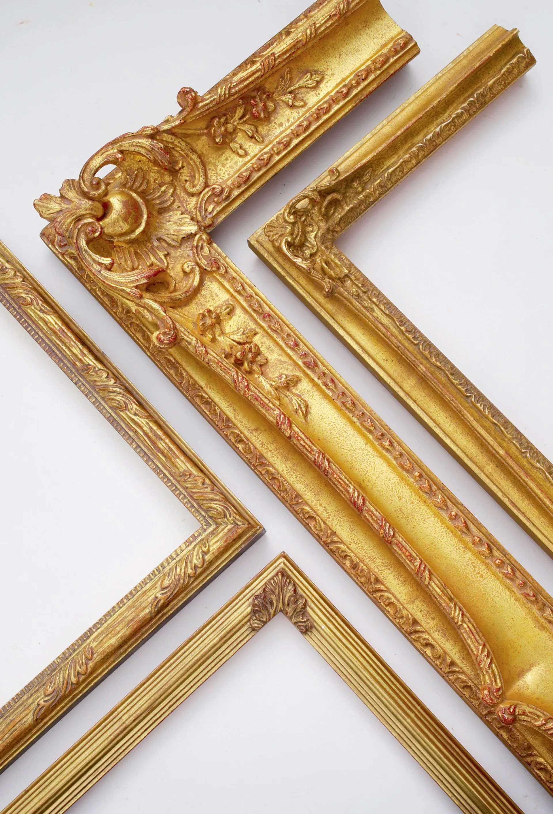 Three ornate, decorative gold picture frame segments arranged diagonally against a plain white background.